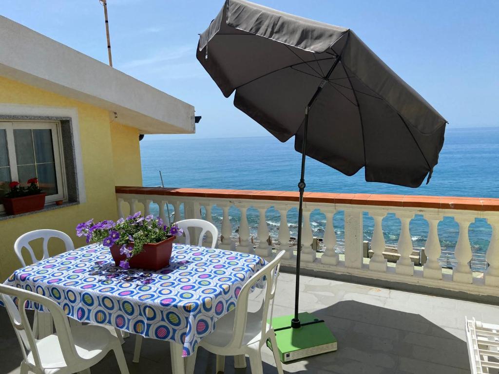 una mesa con sombrilla en el balcón en A picco sul mare, en Marina