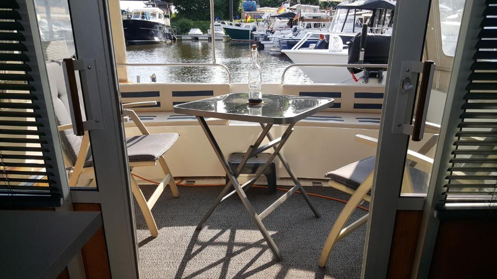 una mesa con una botella de cristal en un barco en Kappoleni - ein Boot für dich, en Lauenburgo/Elbe