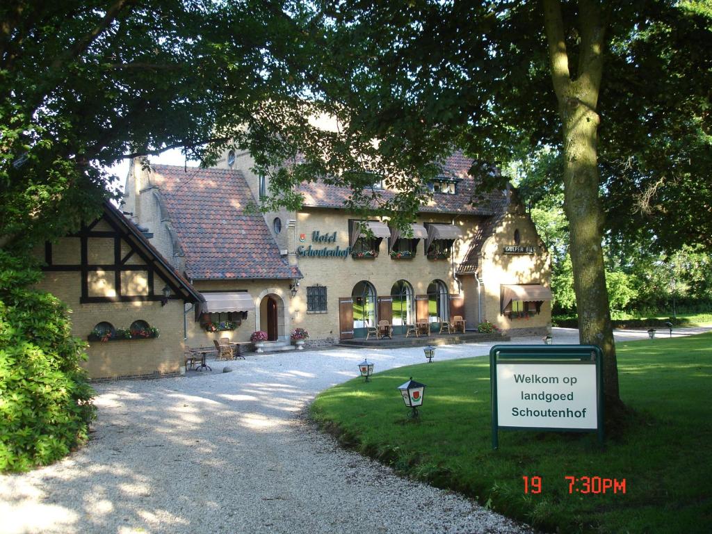uma casa grande com um sinal em frente em B&B - Landgoed Schoutenhof em Epen
