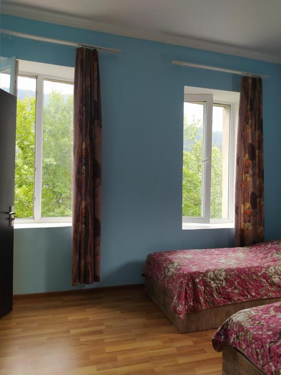 1 Schlafzimmer mit 2 Betten und 2 Fenstern in der Unterkunft Barbara in Mestia
