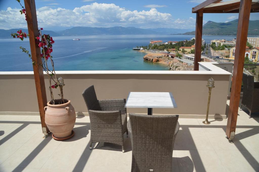 una mesa y sillas en un balcón con vistas al agua en Lydia Apartments, en Loutra Edipsou