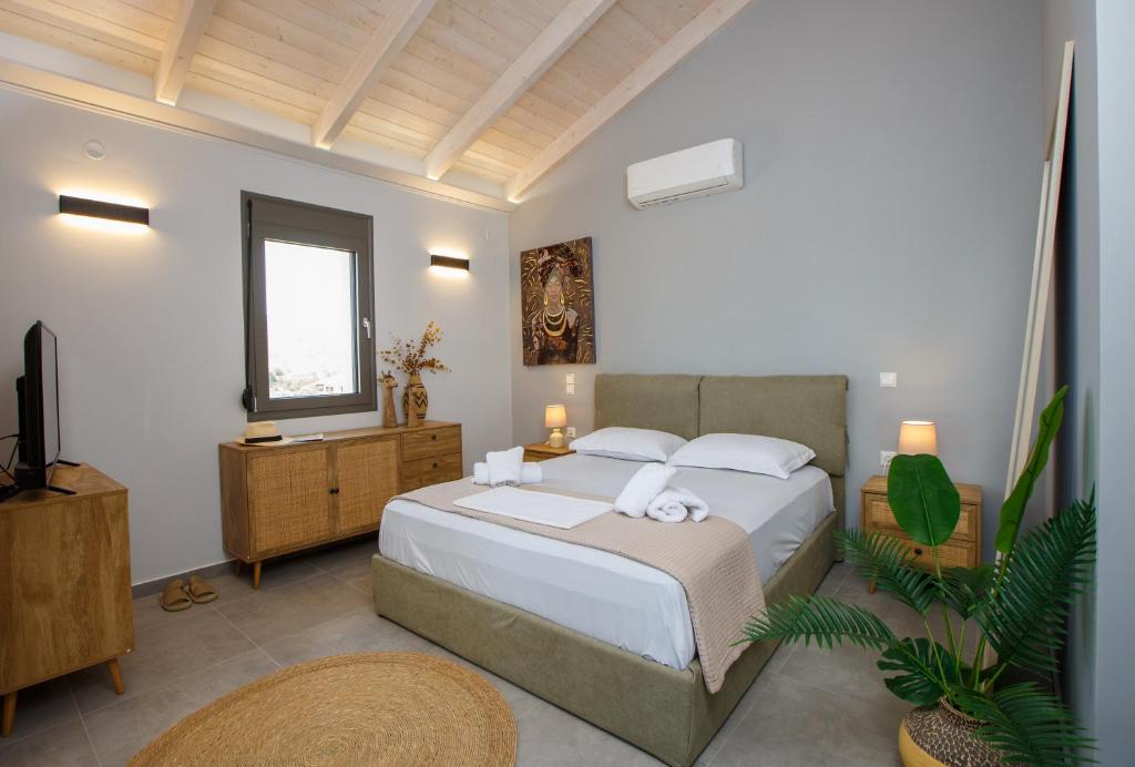 a bedroom with a large bed and a television at Théa boutique villas sivota III in Sivota