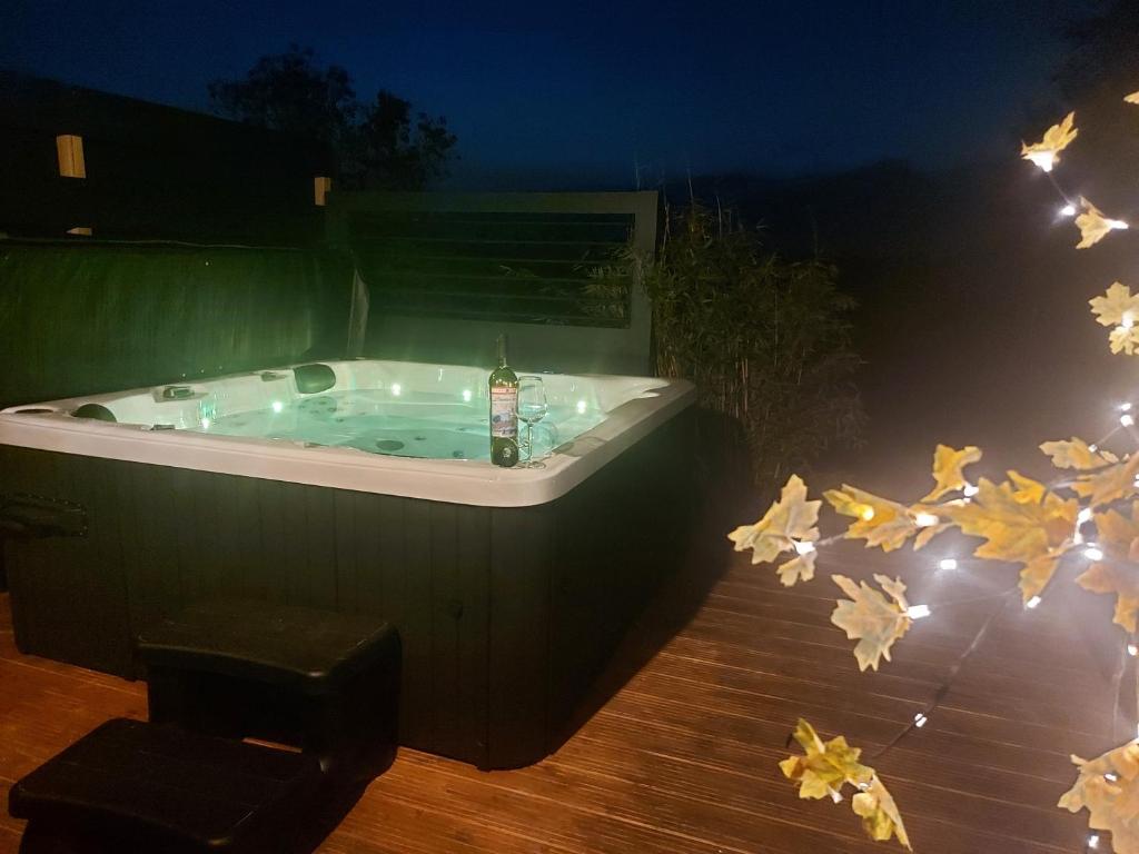 eine Whirlpool-Badewanne im Garten in der Nacht in der Unterkunft Jacuzzi huisje De Berenshoeve in Emmen