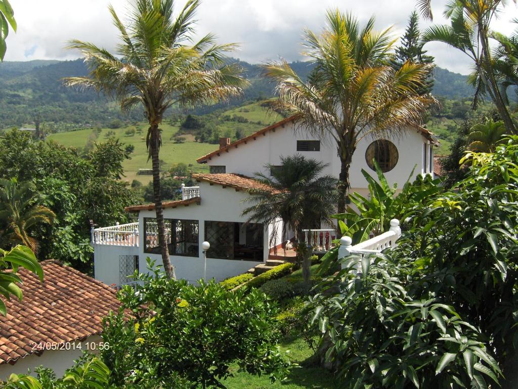 a white house with palm trees in front of it at Silvania, Ferienhaus - Casa Campestre in Silvania