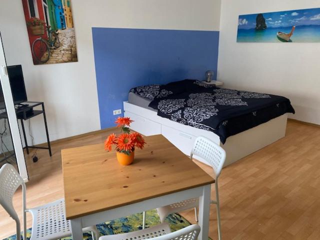 una camera da letto con un letto e un tavolo con dei fiori sopra di Vida Real Estate Nürnberg a Norimberga