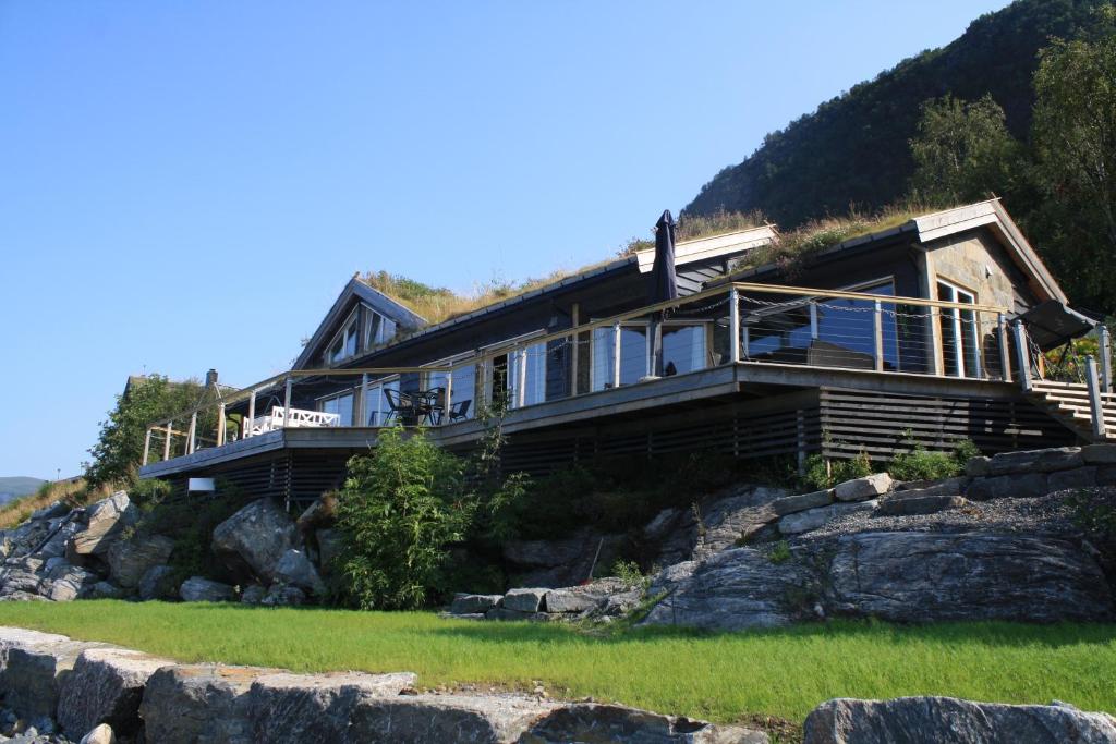 una casa al lado de una montaña en Småstranda Fjord Lodge en Åheim