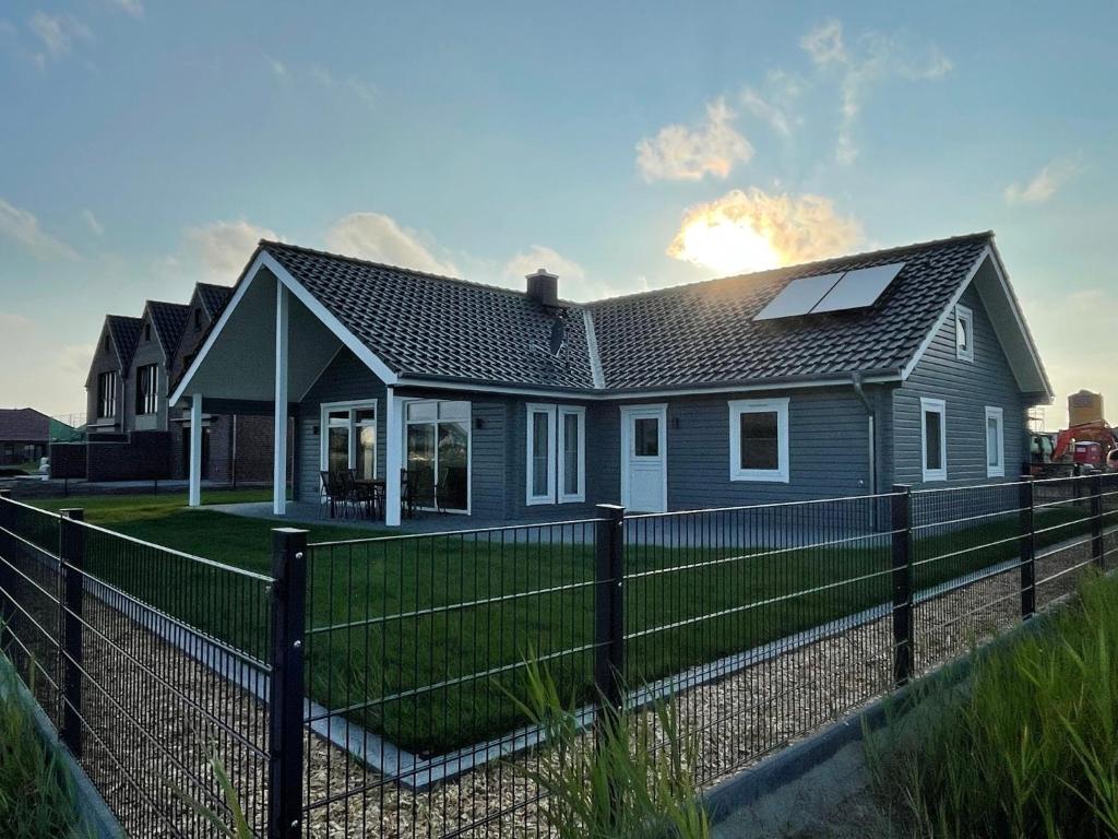 a house with a fence in front of it at Wangermeer - Ferienhaus in Wangerland