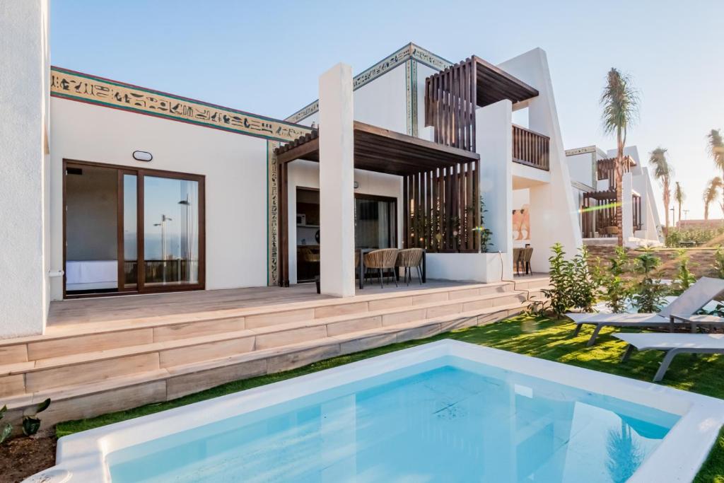 eine Villa mit einem Pool und einem Haus in der Unterkunft Grand Luxor Village in Benidorm