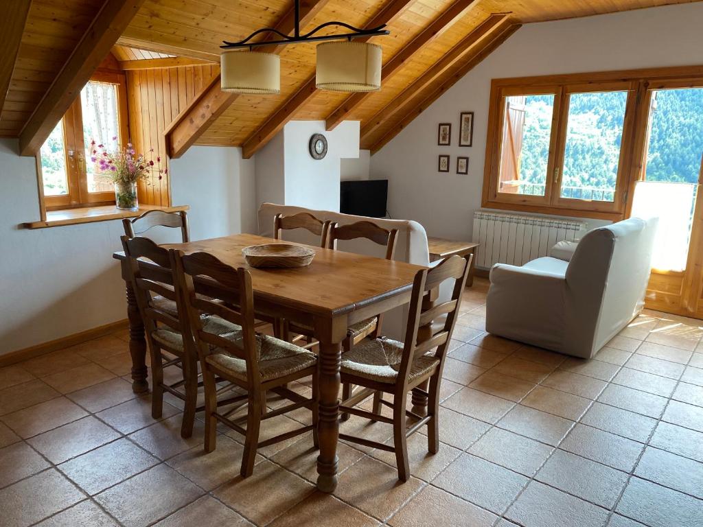 uma sala de jantar com uma mesa de madeira e cadeiras em Apartaments Ca de Badia em Taull