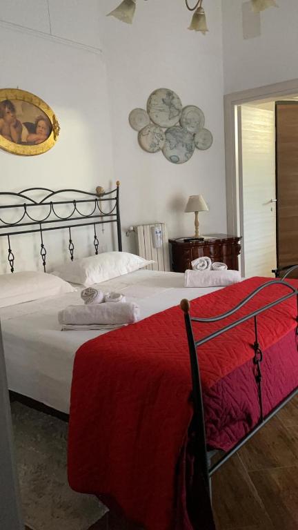 a bedroom with a large bed with a red blanket at B&B Nonna Ninina in Olevano sul Tusciano
