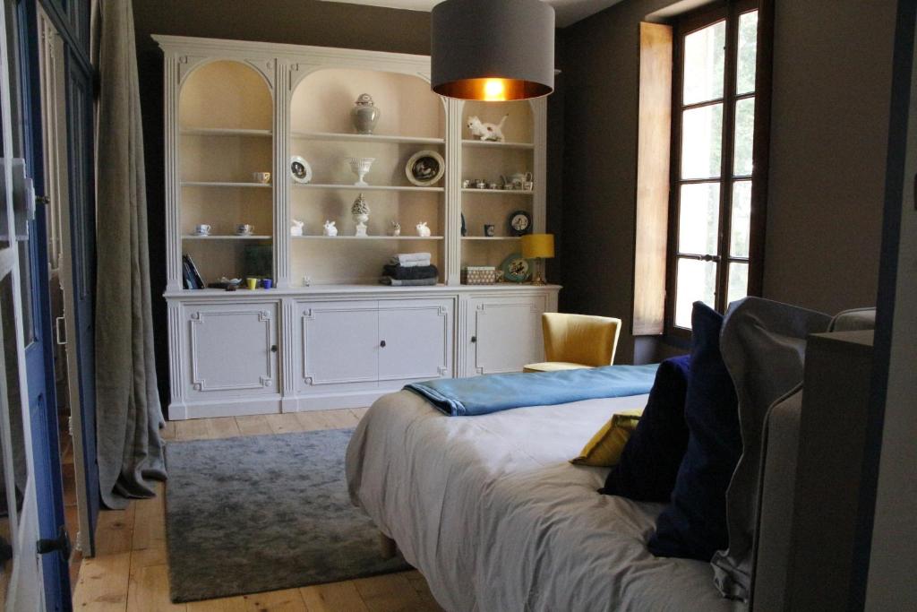 a bedroom with a white cabinet and a bed at Rouge Maison in Bois-Normand-près-Lyre