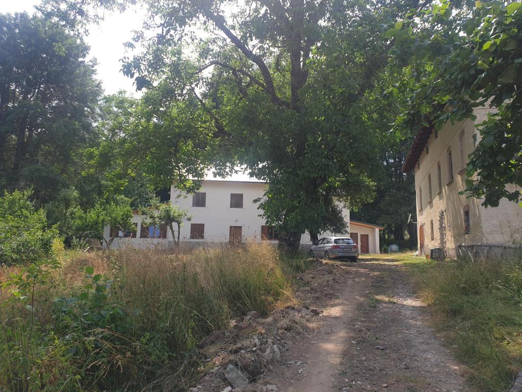 un chemin de terre devant un bâtiment blanc dans l'établissement Agriresort Tenuta Ranieri, à Camigliatello Silano