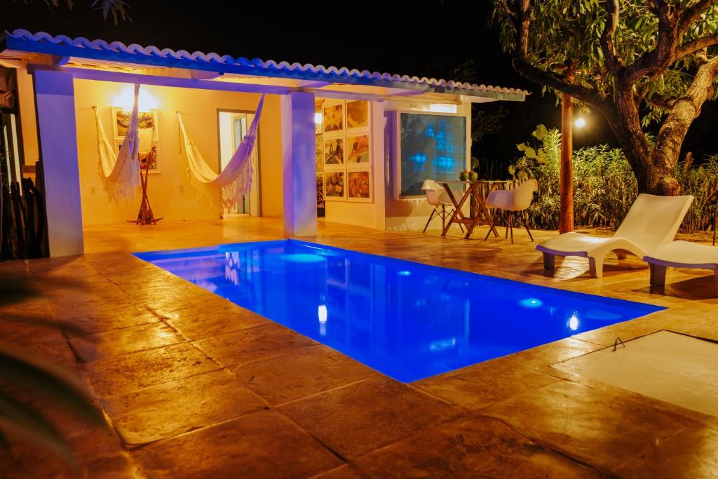 a swimming pool in the middle of a yard at night at Refugios Parajuru - Casa Manga in Parajuru