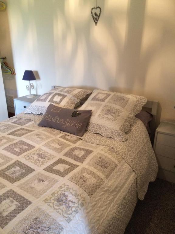 a bed with a quilt on it in a bedroom at La Boulangerie in Romagny