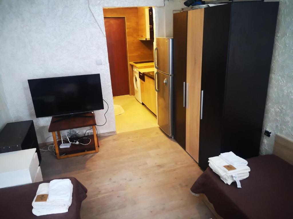 een woonkamer met een televisie en een keuken bij Studio- Krasi in Varna