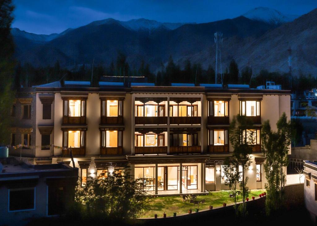 ein großes Gebäude mit nachts eingeschaltetem Licht in der Unterkunft The Bodhi Tree in Leh