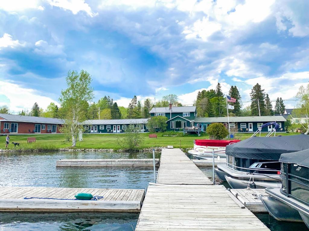 a dock with boats on the water in front of houses at Rangeley Town & Lake in Rangeley