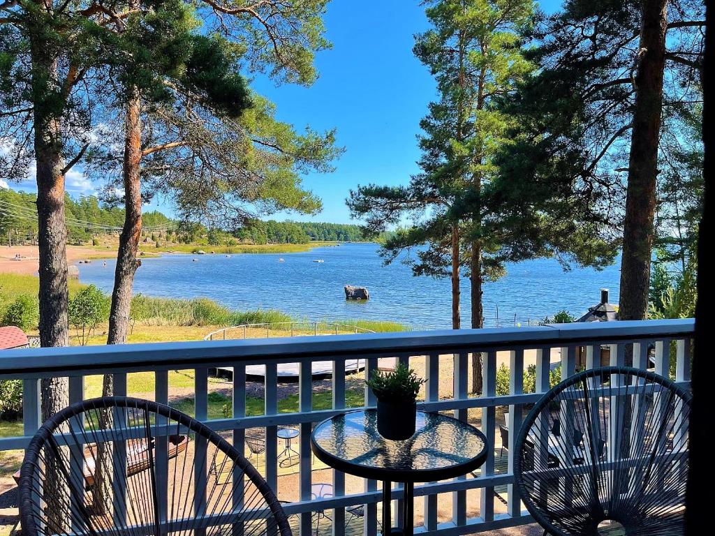 een tafel en stoelen op een balkon met uitzicht op een meer bij Beach Hotel Santalahti in Kotka