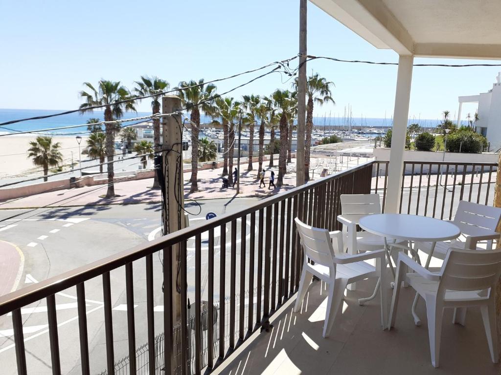einen Balkon mit Tisch und Stühlen sowie Strand in der Unterkunft Apartamentos Dins Mar Apto. 5 in Torredembarra