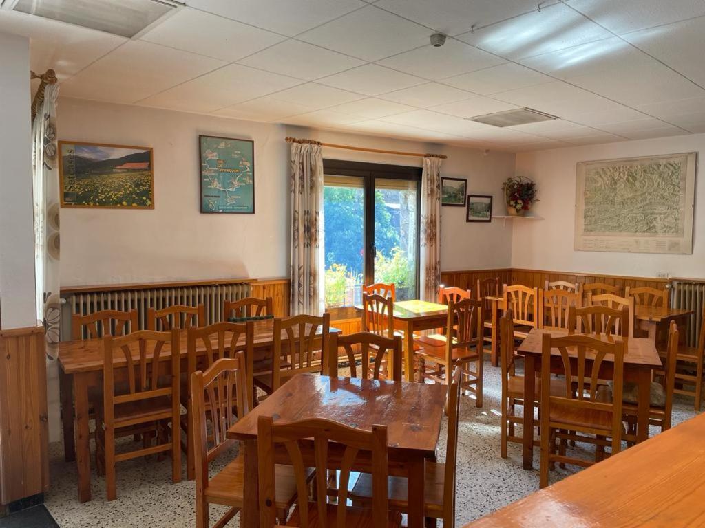 Hostal Ter في سيتكاساس: غرفة طعام مع طاولات وكراسي خشبية