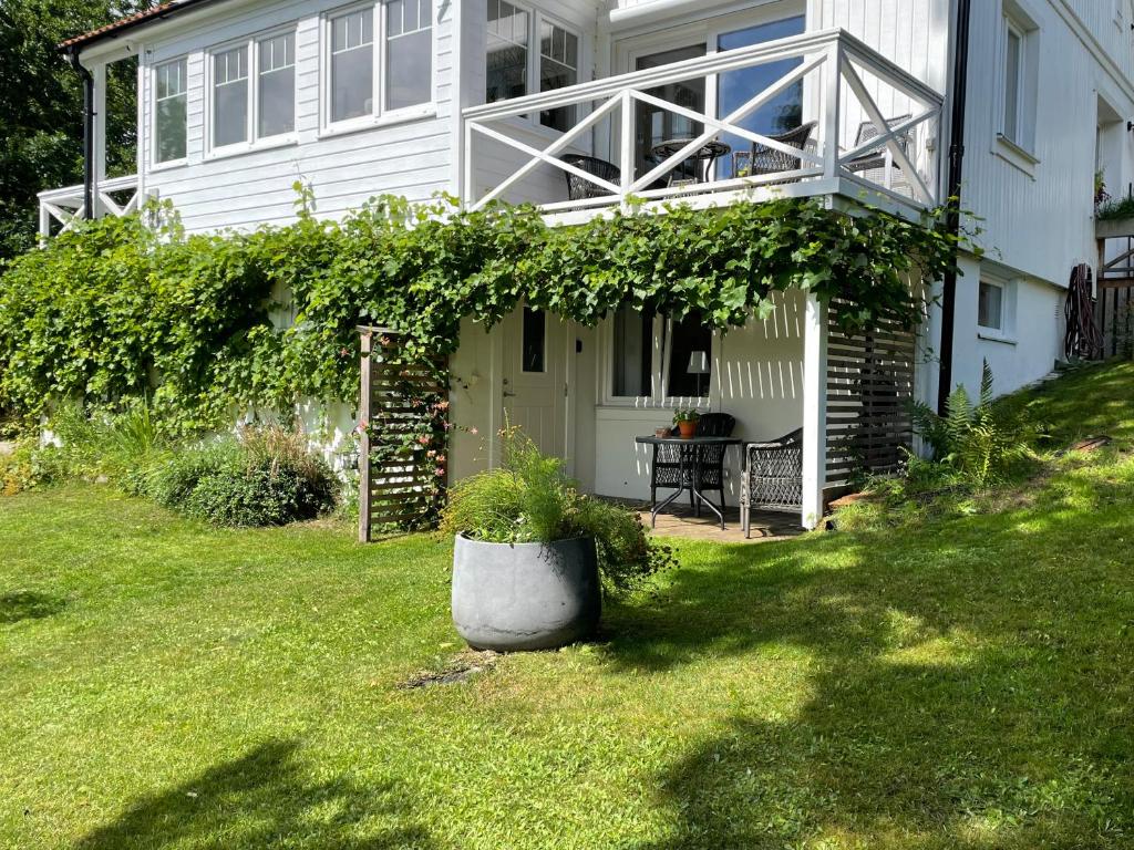 a white house with a porch with a plant in the yard at Villa Kulle in Virserum