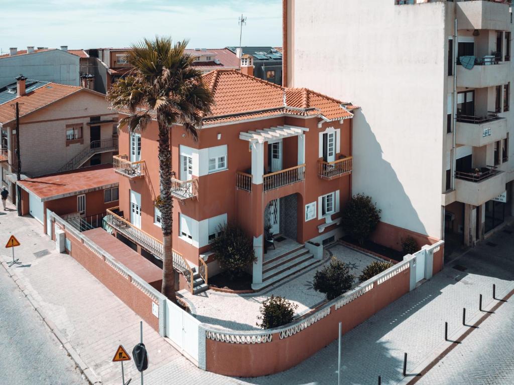 an aerial view of a house with a palm tree at Green Coast Surf House in Espinho