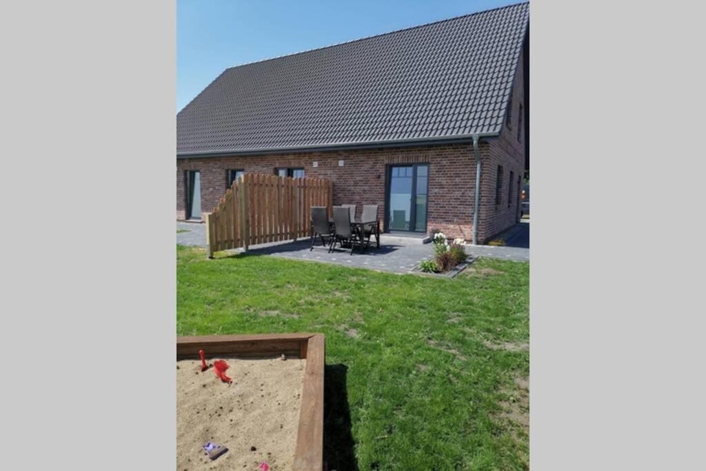 a house with a yard with a table and chairs at Ferienwohnung SteifeBrise in Ockholm