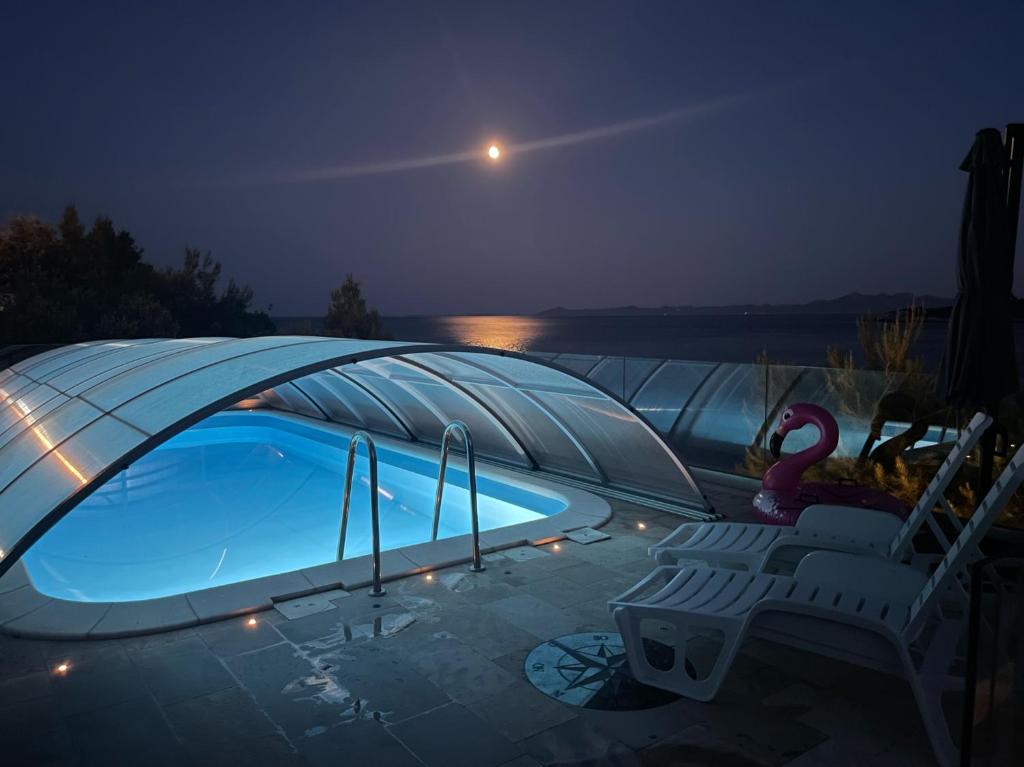 a swimming pool in a iguana tent at night at Villa Desiree in Prizba