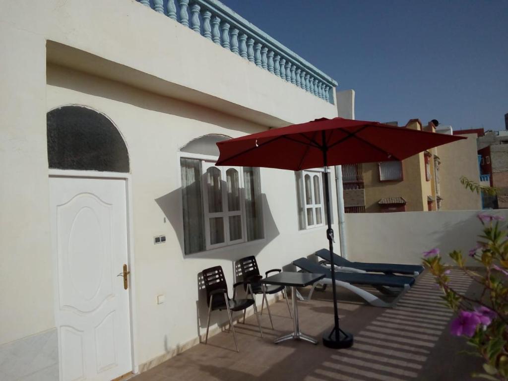 a patio with a table and chairs and an umbrella at amal's apart&studio in Agadir