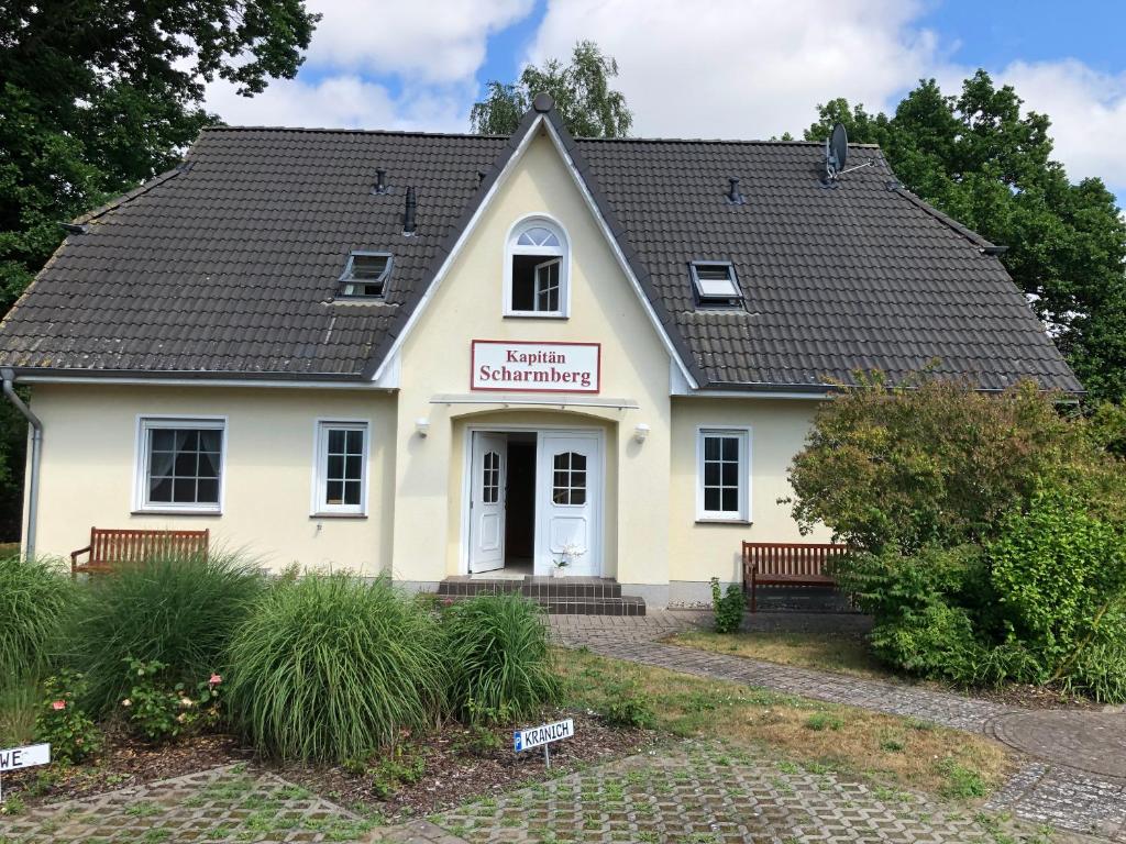 ein kleines weißes Gebäude mit einem Schild drauf in der Unterkunft Kapitänshaus Scharmberg, Ferienwohnung Möwe in Born