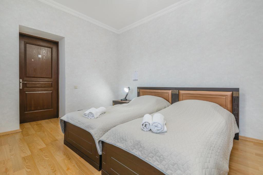 two beds in a bedroom with white towels on them at Alvani Inn in Nizhniy Alvani