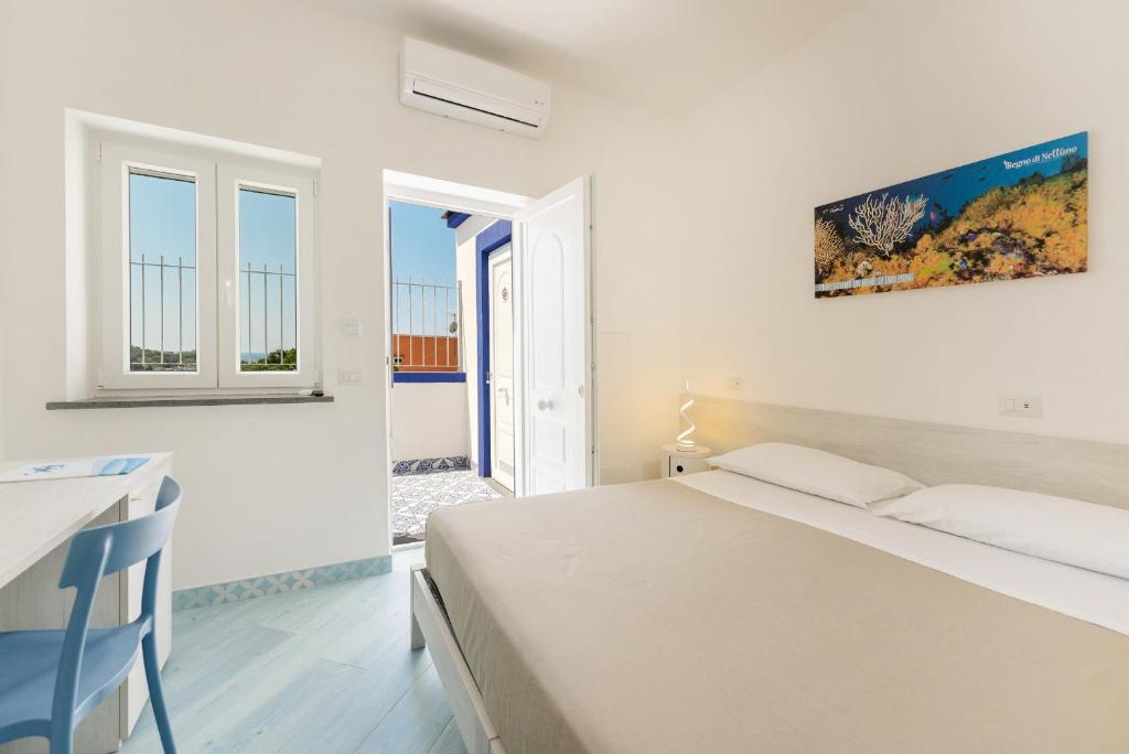 a white bedroom with a bed and a window at Poseidonia Rooms in Procida