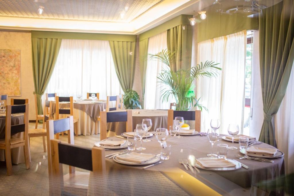 uma sala de jantar com uma mesa com copos de vinho em Sport Hotel & Residence Il Bivacco del Parco em Cutura