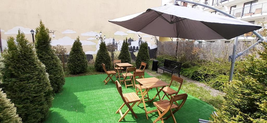 un patio con mesas, sillas y una sombrilla en Chilli Hostel, en Cracovia
