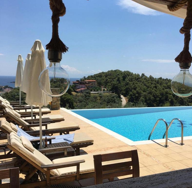 a group of chairs and a swimming pool at Skiathos Garden Cottages in Skiathos Town