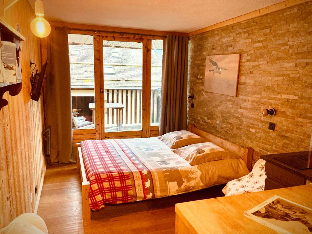 1 dormitorio con 1 cama en una habitación con ventana en Le Gypaète, en Chamonix-Mont-Blanc