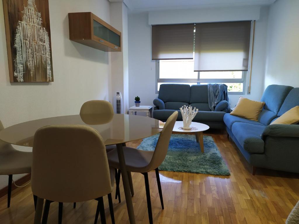 sala de estar con mesa y sofá azul en Apartamento Poniente con dos baños centrico, en Logroño