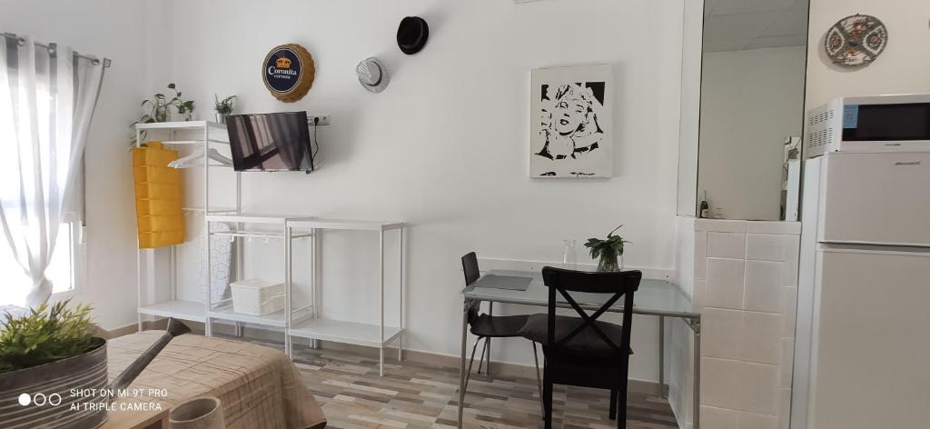 a white kitchen with a table and a refrigerator at Huelintown in Málaga