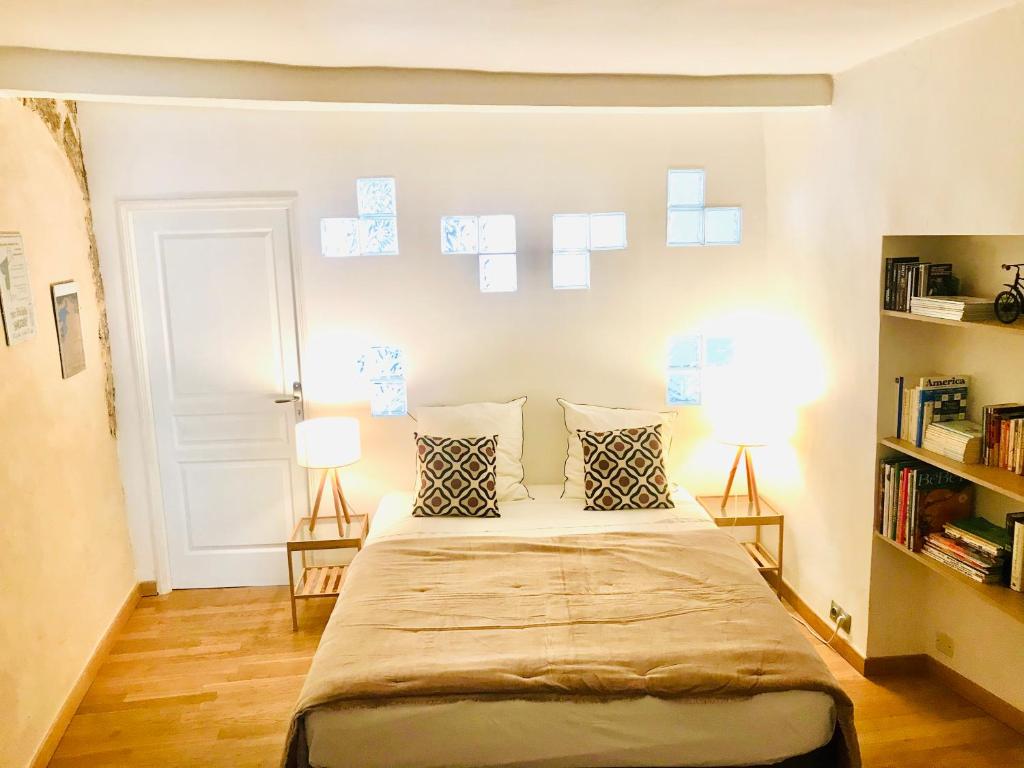 a bedroom with a bed with two lamps and a book shelf at Appartement Lavande et Jasmin in Anduze