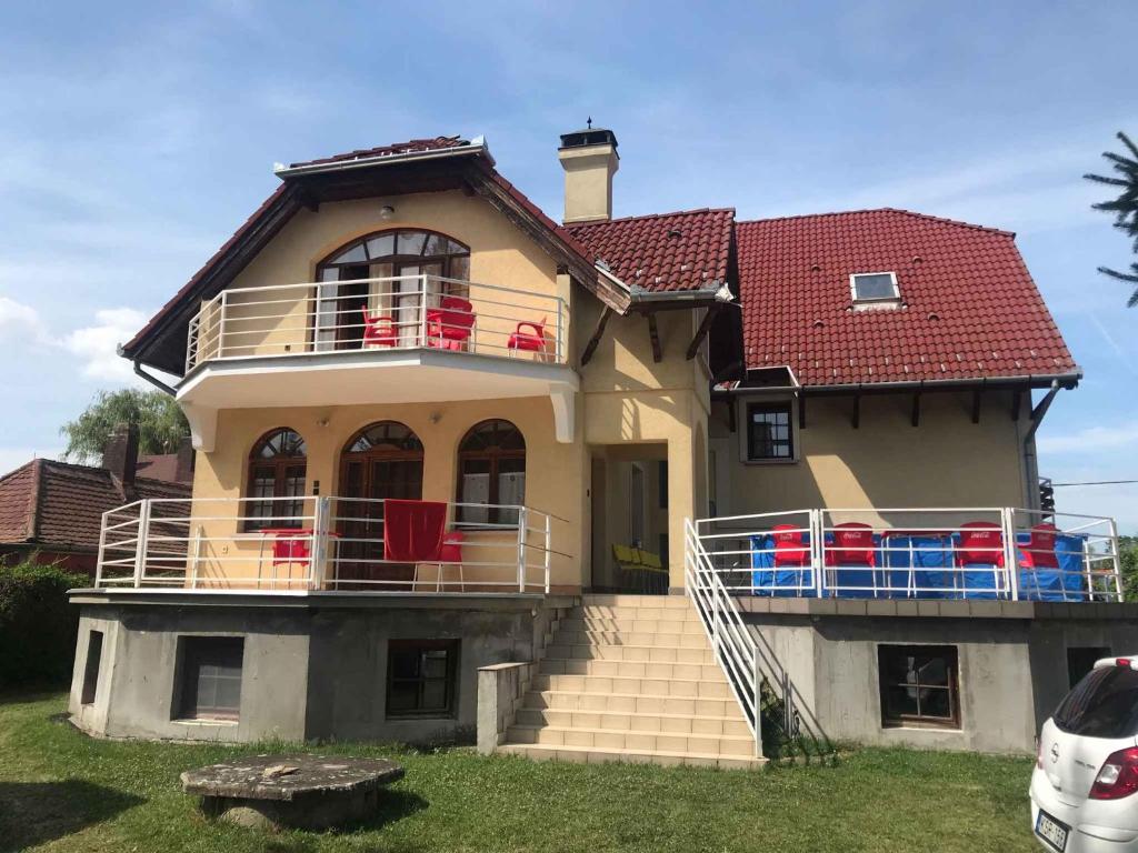 Apartments in Balatonmariafürdo 37115 في بالاتونكريستور: منزل مع شرفة مع سقف احمر