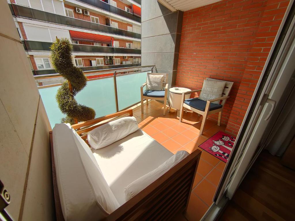 Un balcón con una cama y una planta en un edificio en Agora Apartments, en Lleida