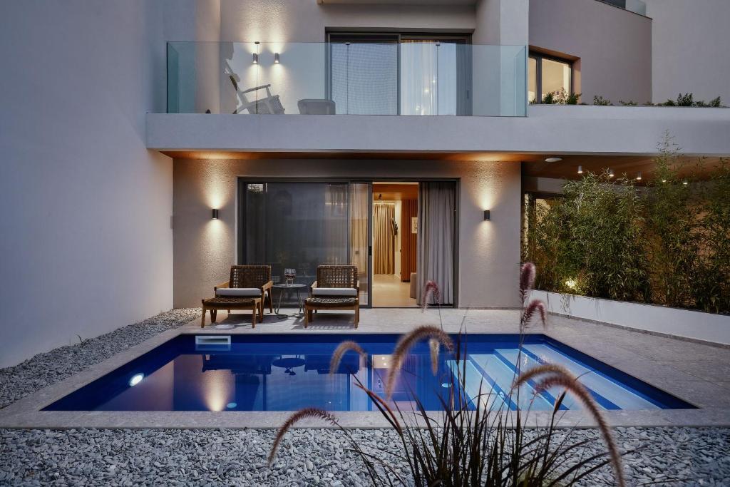 a house with a swimming pool in front of it at Origami Boutique Residences in Nafplio