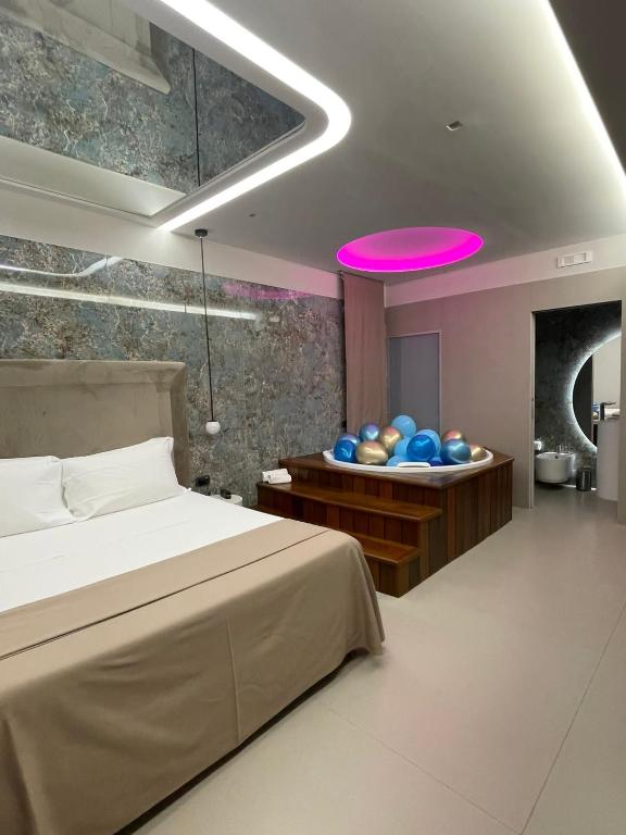 una camera con letto e soffitto rosa di Hotel 2000 a Giugliano in Campania