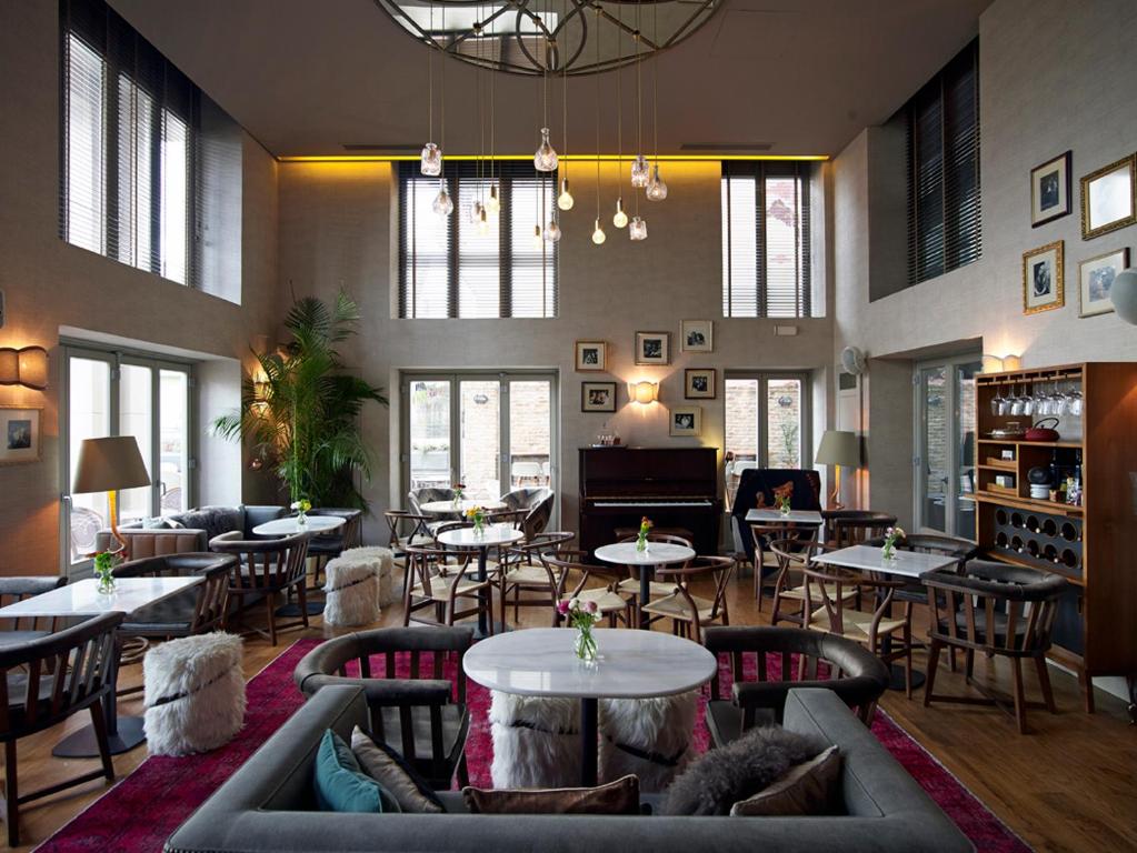 a restaurant with couches and tables and a piano at Marpessa Hotel & Spa in Agrinion