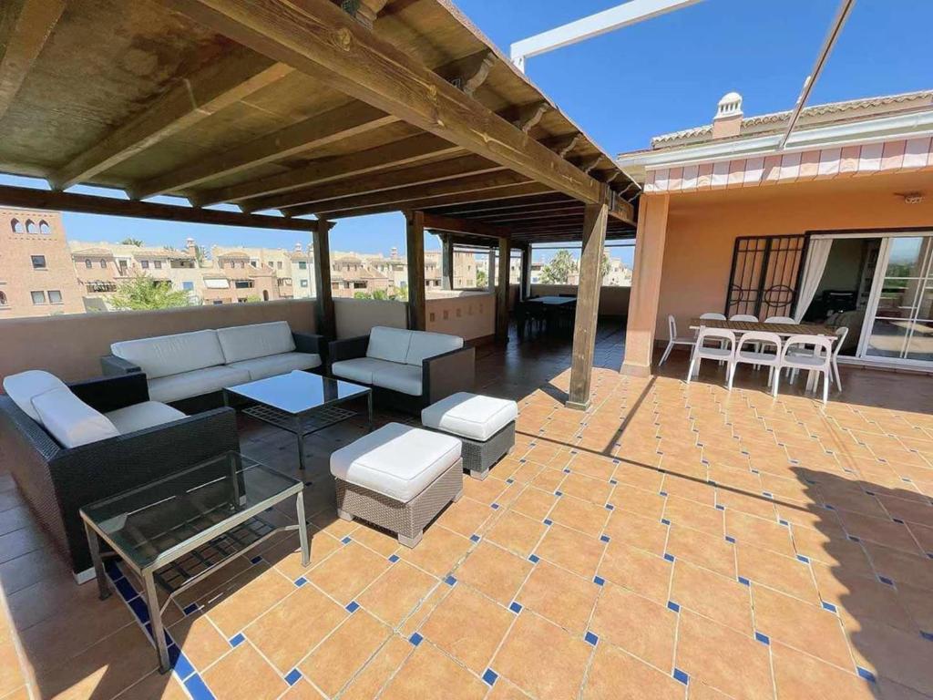 une terrasse avec un canapé, une table et des chaises dans l'établissement Atico - 3 Dormitorios - Urbanizacion Verazul en Vera Playa - WIFI Fibra 300MB perfecto para Teletrabajo, à Vera