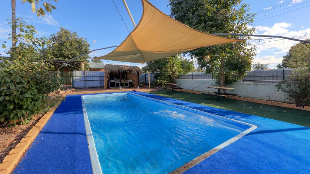 a swimming pool with a canopy over it at Townview Motel in Mount Isa