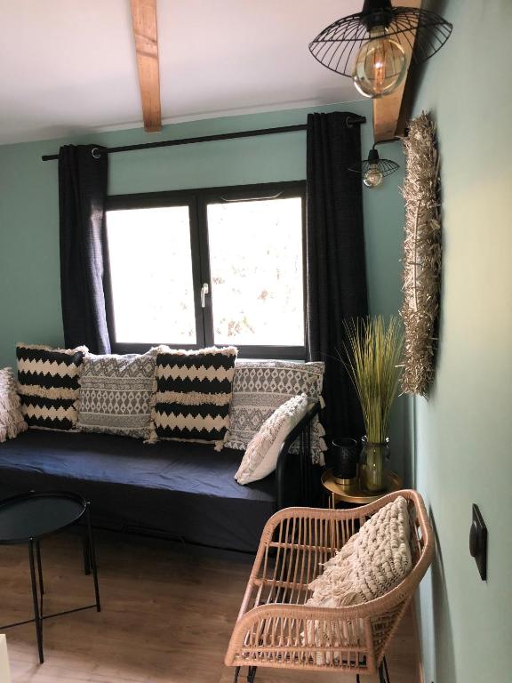 Cette chambre dispose d'une fenêtre avec un canapé et des chaises. dans l'établissement Le petit clocher de Cassis, à Cassis