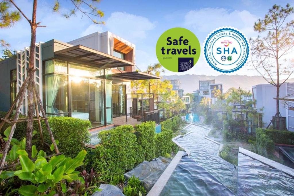 une maison avec une piscine et un panneau indiquant que vous voyagez en toute sécurité dans l'établissement Green Pix Khaoyai, à Pak Chong