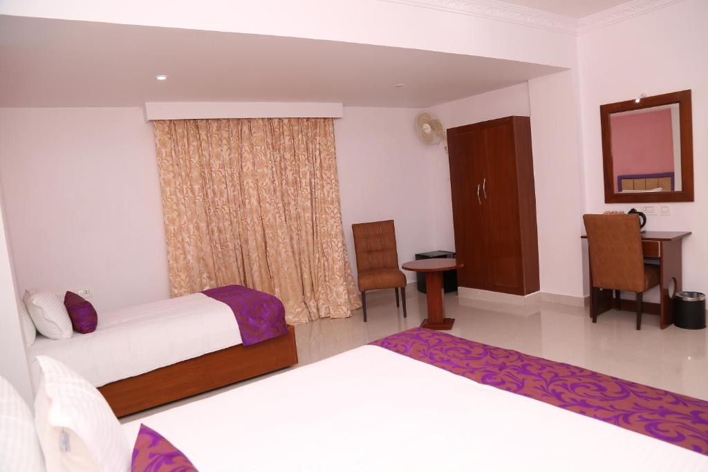 a hotel room with two beds and a window at Sbk Park Inn in Kanchipuram