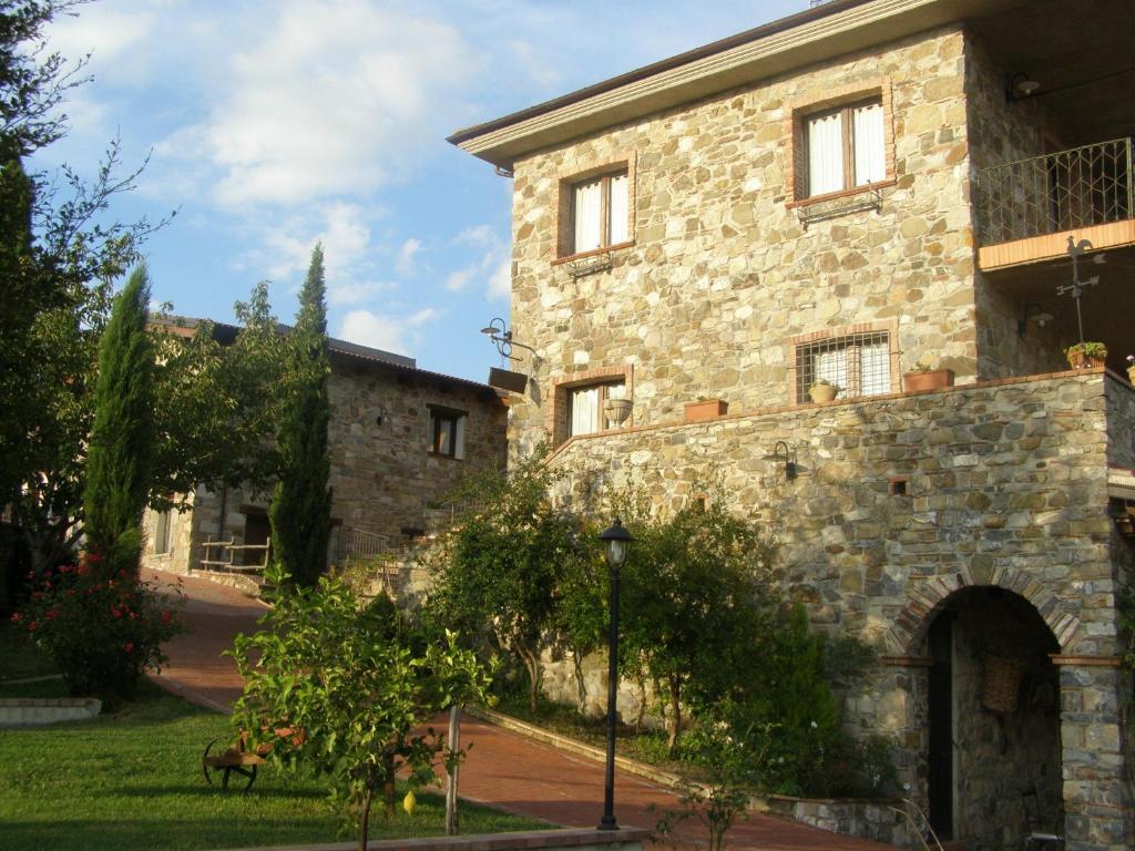 - un grand bâtiment en pierre avec une cour en face dans l'établissement B&B Le Grazie, à Piaggine